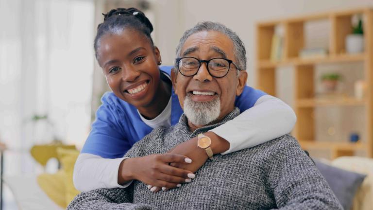Woman in scrubs with an older gentleman